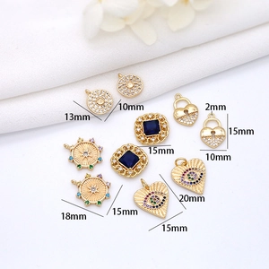 Detail view of 14K gold plated heart and gemstone pendants with size labels for DIY