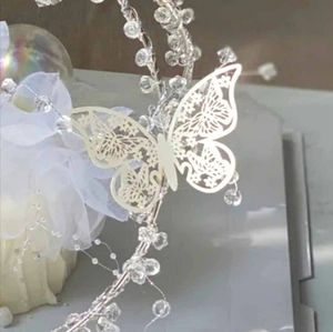 Close-up of ivory 3D hollow paper butterfly with elegant pearl finish for wall decor