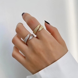 Detail of adjustable 925 silver and gold rings with irregular textured finish on a hand