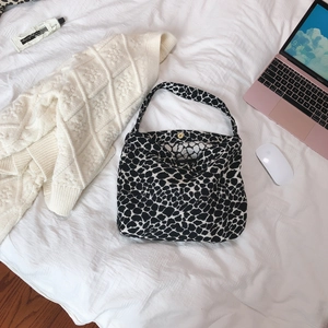 Chic black and white leopard print canvas tote bag with magnetic closure on a white bed
