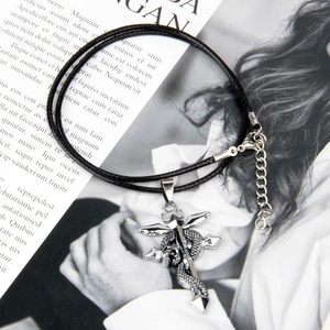 Close-up of a silver winged sword pendant entwined with a snake on a black cord