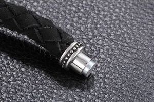 Detail eines schwarzen Lederarmbands mit poliertem Edelstahl-Magnetverschluss im Zoom