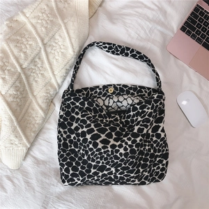 Close-up of black and white leopard print tote bag with golden magnetic buckle closure
