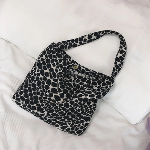 Close-up of black and white leopard print canvas tote bag with golden magnetic clasp