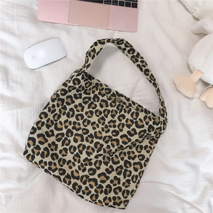 Close-up of leopard print canvas bag featuring a round metal magnetic snap closure