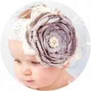 Close-up of baby lace headband with dusty purple flower and pearl center on a child