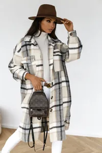 Detailed close-up of plaid wool coat featuring a lapel collar and flap breast pockets