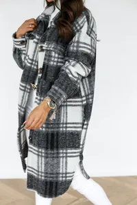 Detail of grey plaid woolen shacket featuring classic buttons and flap chest pockets