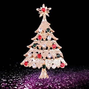 Vue détaillée de la broche sapin de Noël avec strass colorés sur un fond noir élégant