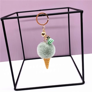 Mint green plush ice cream keychain with golden heart charm and tassel on frame