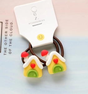 Close-up of cute yellow house cartoon charms on elastic hair ties for kids