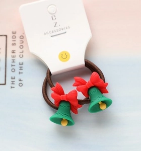 Detail of Christmas hair ties with green bell and red bow charms on display card