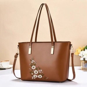 Borsa tote in pelle marrone con elegante ricamo floreale e tracolla regolabile