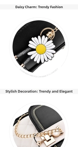 Detail of sunflower charm and cat-ear golden metal buckle on black and white PU leather bag