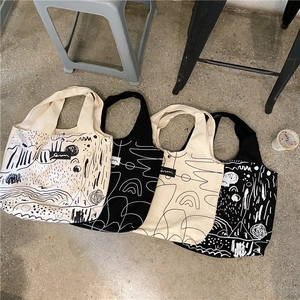 Detail shot of four abstract art print canvas tote bags with chic black and white patterns