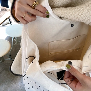 Detail of the internal zipper pocket and raw edge finish of the canvas tote bag