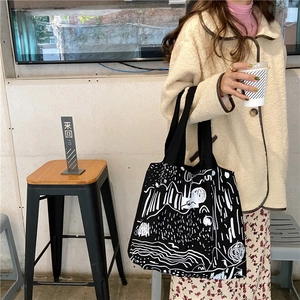 Lifestyle shot of large canvas shoulder bag with abstract white line graffiti design