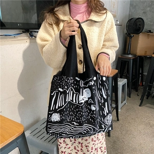 Detail shot of black canvas tote bag with white abstract graffiti and art illustration