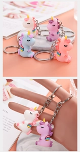 Detail view of unicorn keychain set in pink, purple, blue, and white colors with metal ring