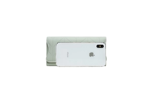 Detailed view of mint green quilted PU leather wallet size compared to an iPhone