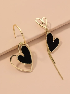 Detail view of asymmetric heart drop earrings with black enamel and golden tassels