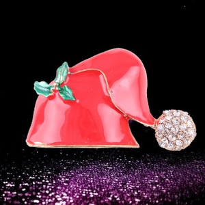 Détail de broche chapeau de Noël en émail rouge avec des cristaux de strass étincelants