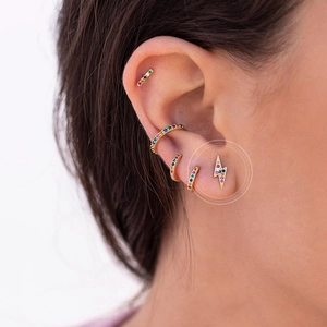Detail of colorful zircon lightning stud earrings and ear cuff set on gold-plated base