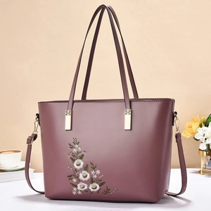 Dettaglio borsa a mano viola scuro con ricamo floreale elegante e minuterie dorate