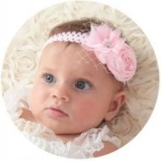 Close-up of pink nylon baby headband with large satin flowers and white lace mesh