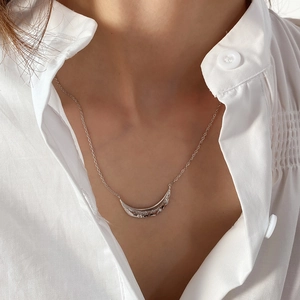 Detailed view of silver branch necklace with hammered texture worn on collarbone