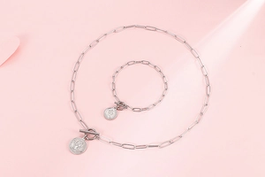 Détail de l'ensemble collier et bracelet à maillons argentés avec pendentifs pièces