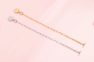 Détails des bracelets à boucle OT en or et argent avec pendentifs ronds sur fond rose