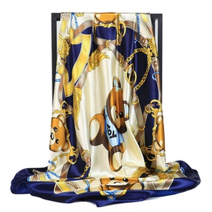 Detail of silk satin scarf featuring luxury chain patterns and cute teddy bear prints