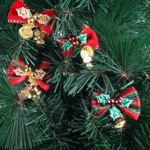 Set of 4 red Christmas bows with small golden bells on green holiday tree branches