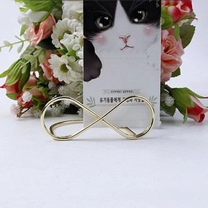 Detail view of a gold infinity-shaped metal table number holder with floral decor
