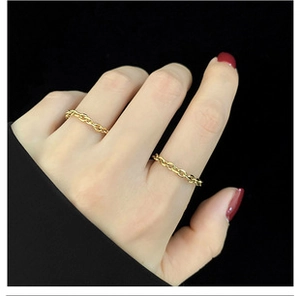 Detailansicht von zwei minimalistischen goldenen Gliederkettenringen am Finger eines Models