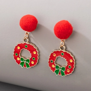 Detailed view of Christmas wreath earrings with red pom poms and enamel bow design