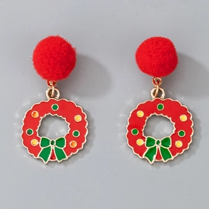 Detail of Christmas wreath earrings with red pom poms and green bow on grey background