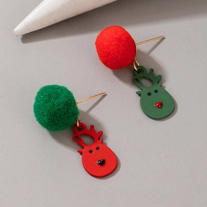 Close-up of Christmas earrings with red and green pom poms and metal reindeer charms