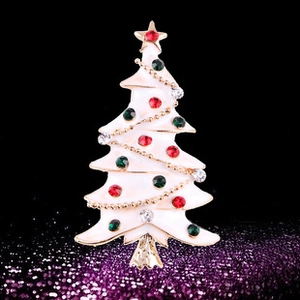 Détail d'une broche sapin de Noël en émail blanc avec des strass rouges et verts