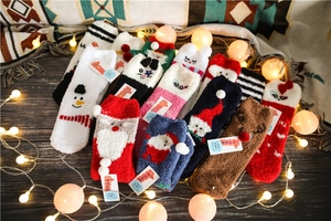 Close-up of thick coral fleece Christmas socks with festive elk and Santa patterns