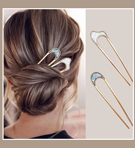 Detail of vintage gold U-shaped hair pins with iridescent shell inlay on an elegant updo