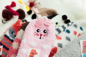 Close-up of soft coral fleece Christmas socks featuring plush 3D animal textures and patterns