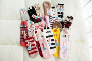 Detail of colorful coral fleece socks with 3D animal patterns like reindeer and pandas