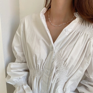 Detailed view of silver interlocking circle link necklace worn on a female model