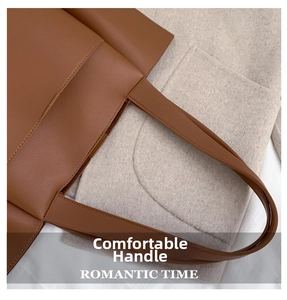 Detail of a brown lychee pattern leather tote bag showing a wide handle and side pocket