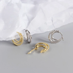 Detailed close-up of double-loop S925 silver earrings with zircon pave and metallic finish