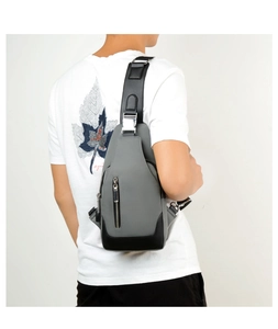 Rear view of a stylish grey and black oxford sling bag worn by a model in a white t-shirt