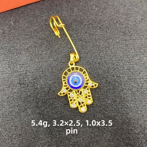 Detailed view of Hamsa Hand safety pin brooch with blue Evil Eye and white crystals
