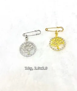 Close-up of gold and silver tree of life brooches with rhinestones and dimensions
